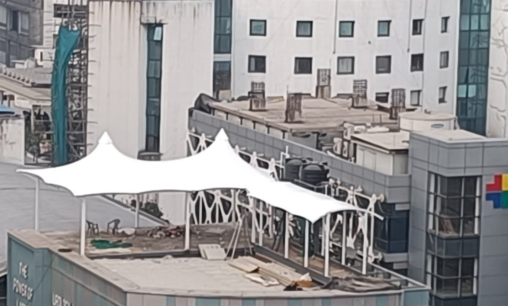 Wide-span industrial tensile structure over a factory loading bay